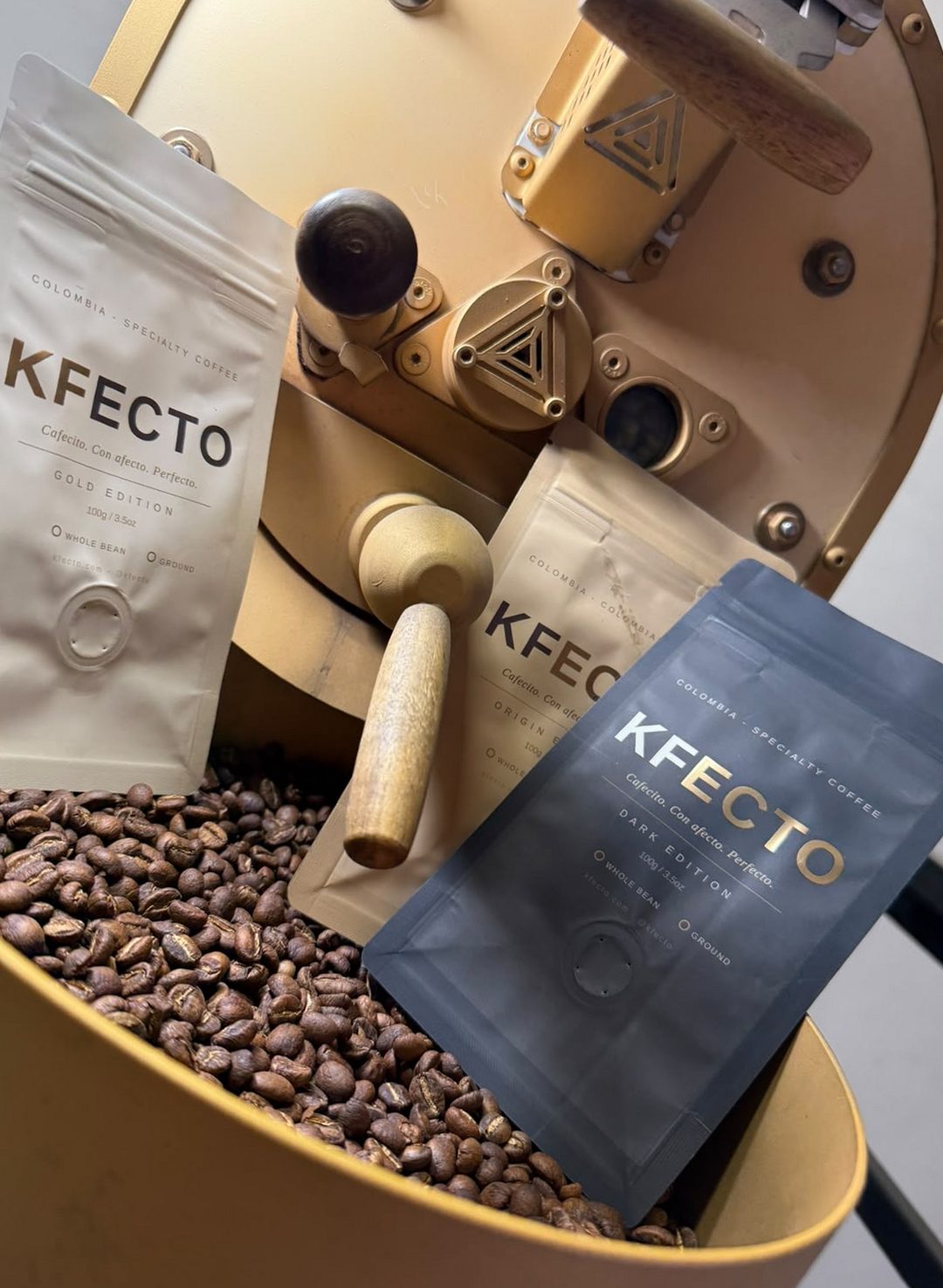 KFECTO Gold, Origin and Dark Edition bags in a coffee roaster full of freshly roasted beans